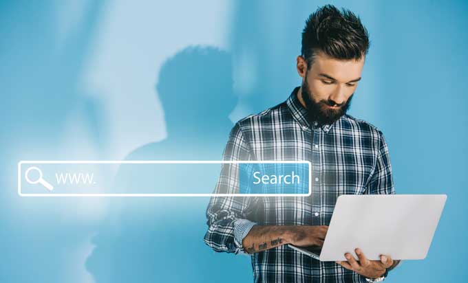 Person using a laptop to search for the right WordPress search plugin